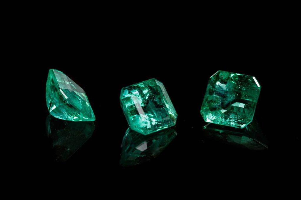 macro mineral emerald gemstone faceted on black background